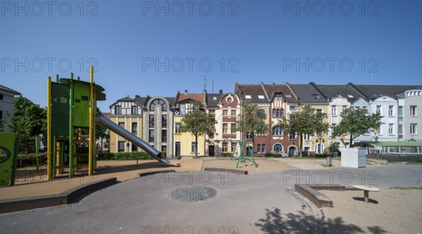Krefeld, row of houses and playground at Anne-Frank-Platz