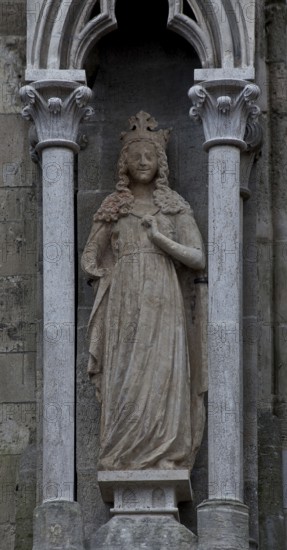 Sculpture of a crowned virgin in the left buttress canopy on the north side of the three western