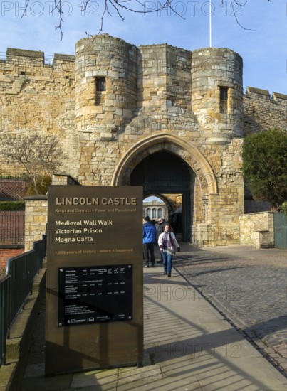 People outside entrance gateway to Lincoln castle, city of Lincoln, Lincolnshire, England, UK