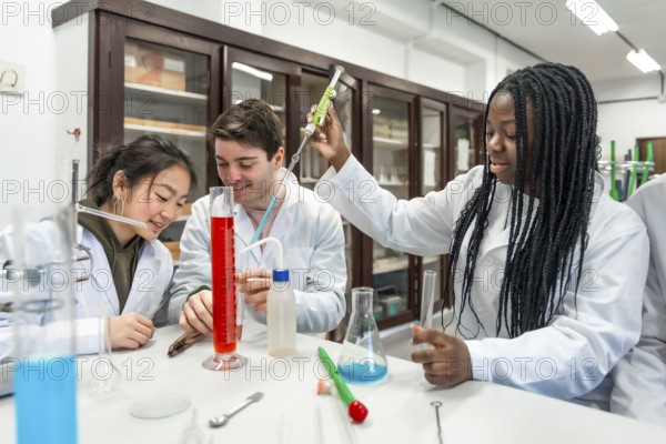Multi ethnic university students wearing lab coats conducting a chemistry experiment using colorful