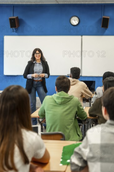 Cheerful professor is teaching a lesson to a diverse group of university students in a modern