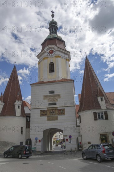 A medieval city gate with high, pointed towers under a cloudy sky, wachaus, donau, austria