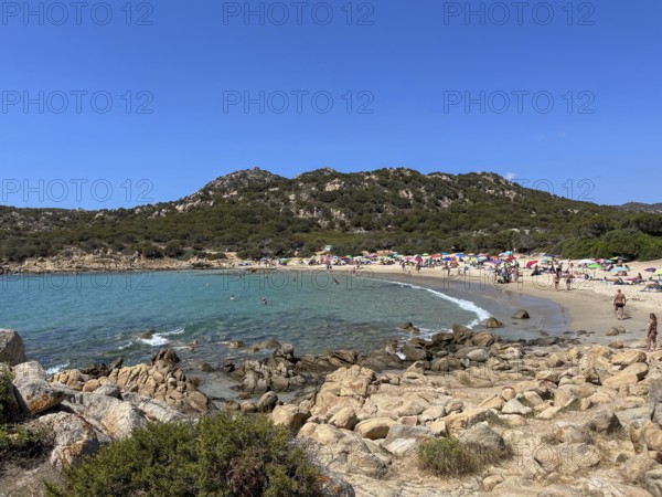 Lively beach with people and blue water, cagliari, sardinia, italy