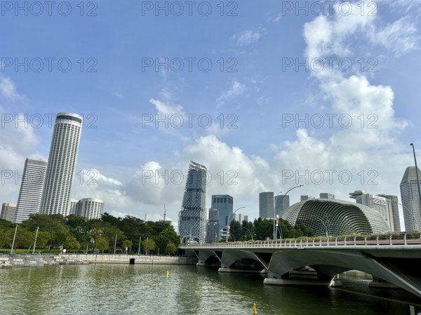 Modern skyscrapers and bridge on the riverside with blue sky and scattered clouds, singapore
