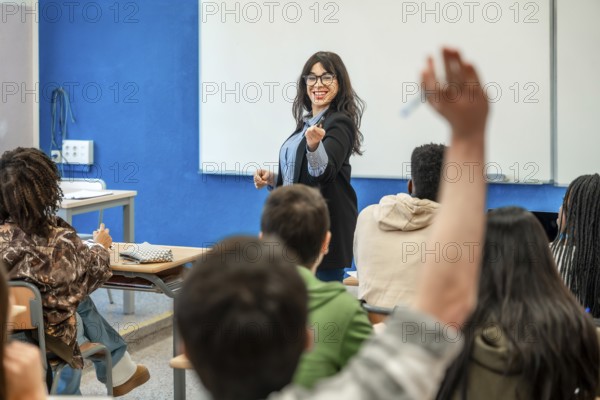 University professor pointing at a student raising hand to answer a question during a lesson in