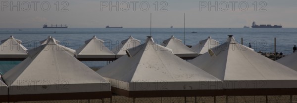 Italy Venice Lido -10 beach tents at the back of the Adriatic Sea with cargo ships in the roadstead