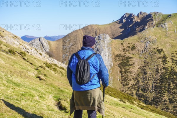 Hiker enjoying the stunning landscape of mount txindoki in gipuzkoa, basque country, on a sunny day