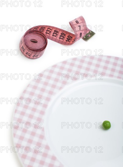 Plate with one peas. Dumbbell and centimetre measure. Studio shot