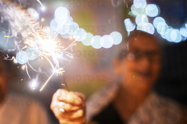 An elderly woman of Pramod Talukdar Memorial Old Age Home burn sparkler crackersas she celebrate