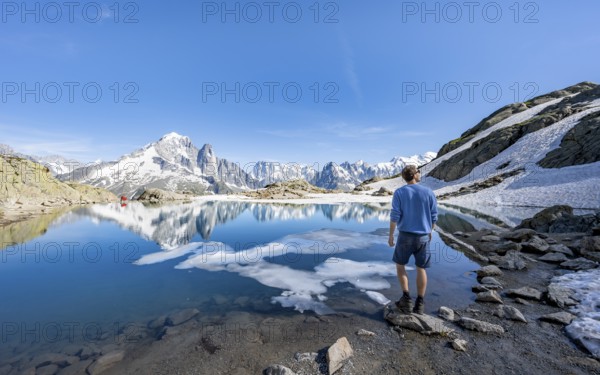 Mountaineer in front of mountain landscape with mountain lake, tourist at Lac Blanc with water