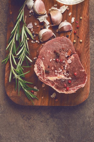 Fresh, raw rib eye steak, on a chopping board, top view, no people