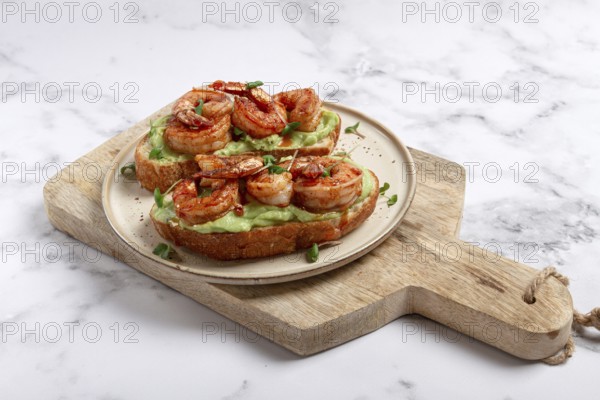 Sandwiches with avocado and caramelized shrimp, micro-greens, breakfast, on a plate, top view,