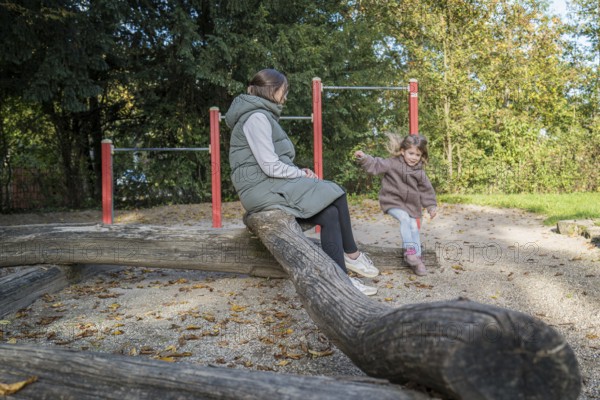 Mother with frolicking child on an autumn playground, Stuttgart, Baden-Württemberg, Germany, Europe