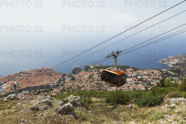 High angle view of cable car transporting tourists from top of Mount Srd down to Dubrovnik city