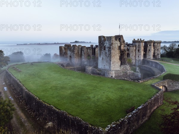 Raglan Castle in the fog at dawn from a drone, Monmouthshire, Wales, England, United Kingdom,