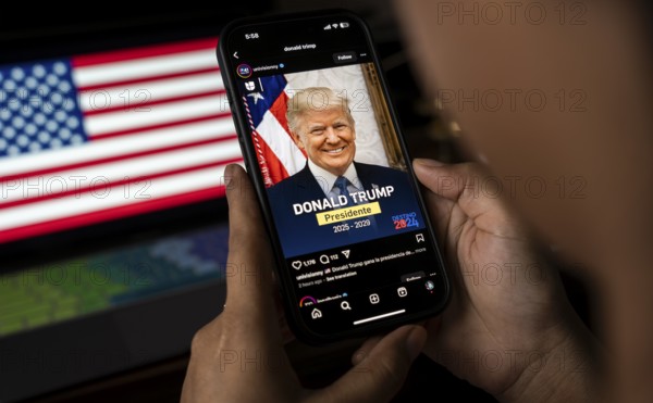 In this photo illustration, a person looks Donald Trump image on a smartphone after results of U.S.