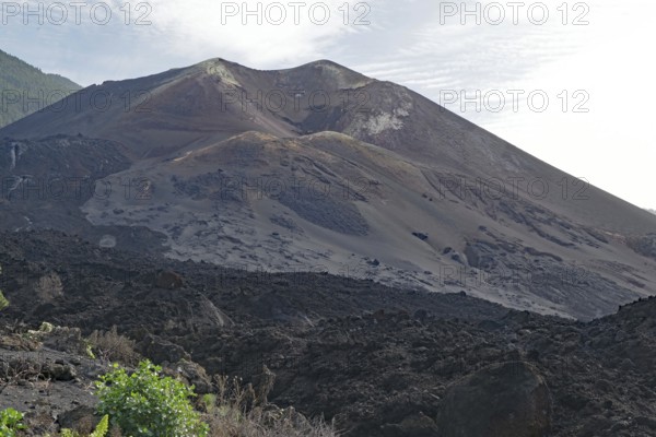 Imposing volcano with dark ash slopes and rocky terrain, last volcanic eruption of Cumbre Vieja,