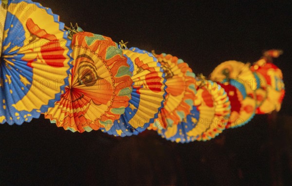 Lanterns attached to a rope during a lantern procession, paper, custom, moon, stars, sky, light,