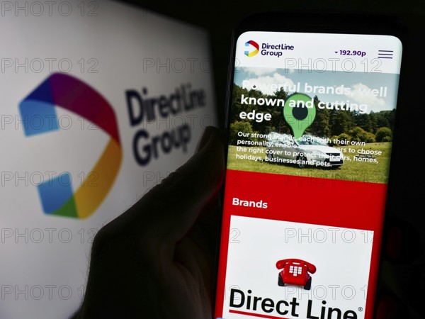 Stuttgart, Germany, 12-08-2023: Person holding smartphone with webpage of British financial company