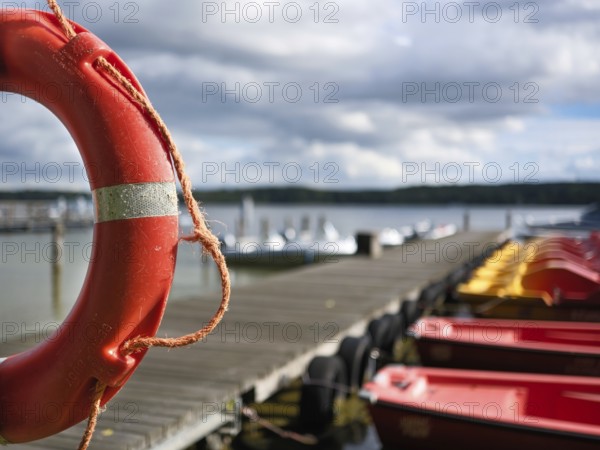 Lifebuoy and boats at the jetty, view over the Scharmützelsee, blurred background, Wendisch-Rietz,