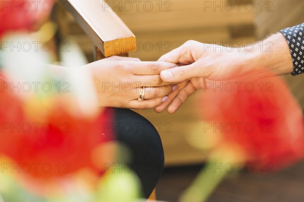 Couple holding hands front blurred rose