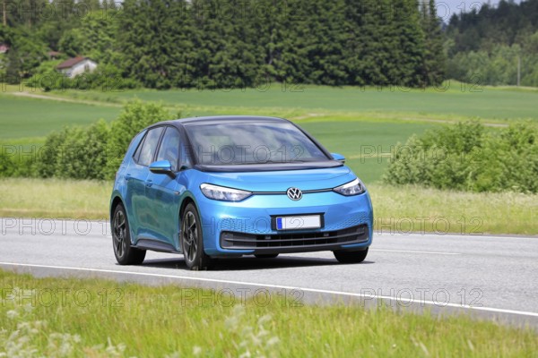 Blue Volkswagen VW ID.3 electric car driving on road on a sunny day of summer. Salo, Finland. June