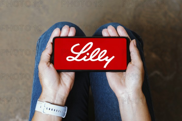 In this photo illustration, the Eli Lilly logo is displayed on a smartphone screen