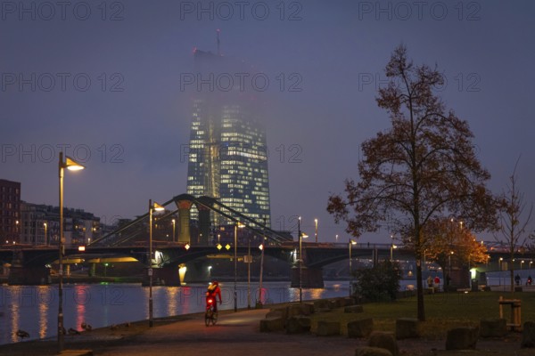Low clouds envelop the illuminated European Central Bank (ECB) in Frankfurt am Main in the evening.