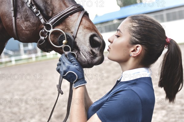 Close up hands of woman hugging a horse. Young girl petting her horse in stable. Equine therapy