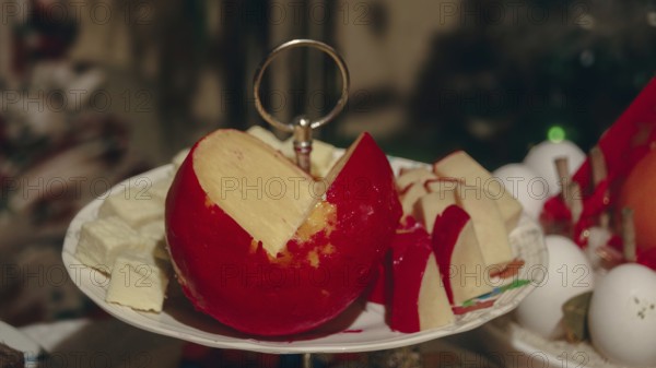 A plate featuring sliced red queso de bola a semi-hard, ball-shaped cheese that's a staple in