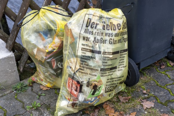 Yellow waste bags for plastic recycling and packaging next to waste bins, Garbsen-Stelingen, Lower
