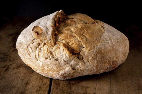 Organic whole wheat round bread on an old wooden table