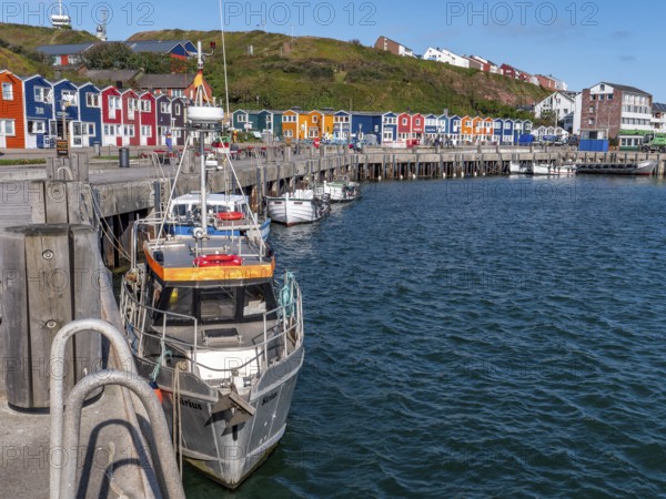 Small fishing boats moored on the shore in the inland harbour and in the background
