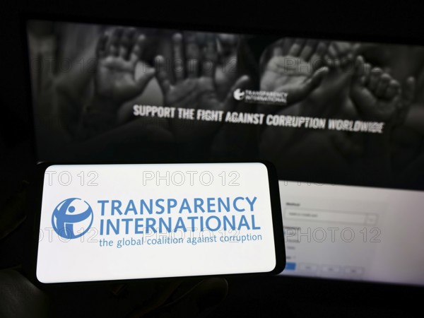 Stuttgart, Germany, 10-02-2022: Person holding cellphone with logo of association Transparency
