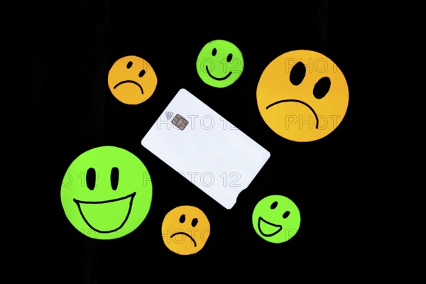 A white plastic card with a chip with contactless payment technology with some drawings of smiling
