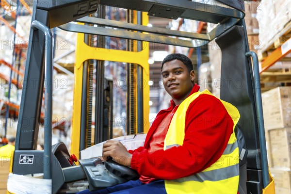 Side view of a happy latin american worker driving forklift in a storage warehouse