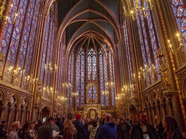 A lively church interior with Gothic architecture and magnificent stained-glass windows,