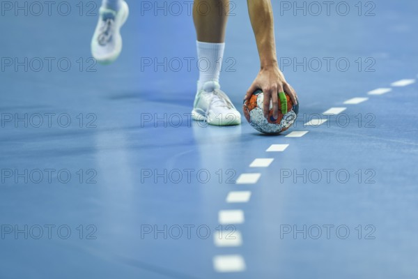 Handball - women's hand taking a ball laying on the 9 meters dotted line.