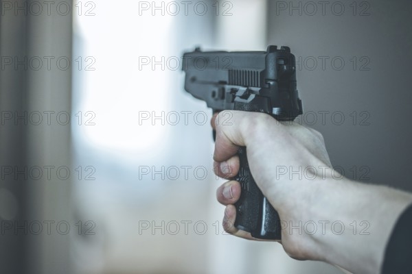 Man is holding a black fire weapon, closeup