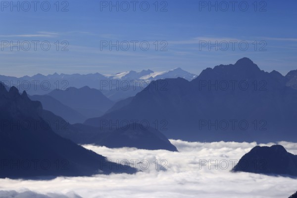 Mountains rising from a closed fog cover, view from Hochstaufen to Großvenediger, morning sun,