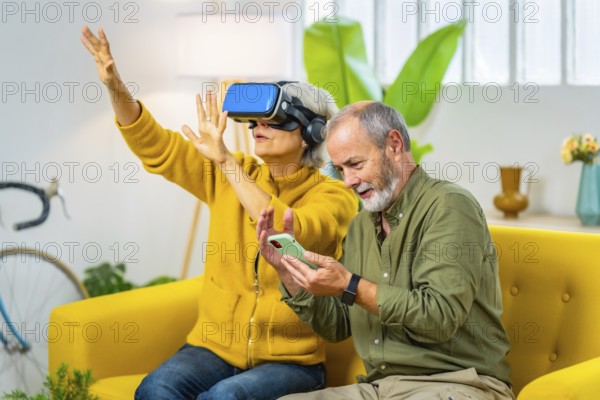 Elderly couple with playing VR game together using virtual reality goggles and mobile phone