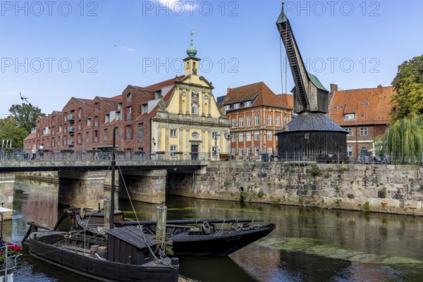 Lüneburg harbour at the Illmenau with old Hanseatic wooden boats, surrounding buildings of the