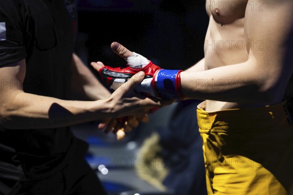 MMA glove on the fighter's hand during the referee's inspection before the fight