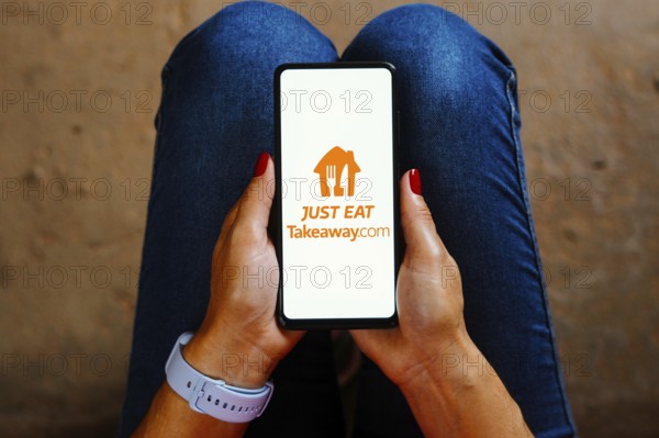 In this photo illustration, the Just Eat Takeaway logo is displayed on a smartphone screen
