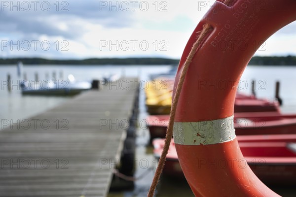 Lifebuoy and boats at the jetty, view over the Scharmützelsee, blurred background, Wendisch-Rietz,