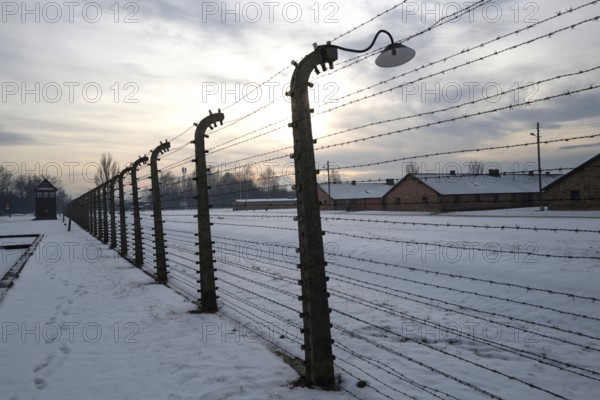 A view of the fence and huts at the entrance to the Auschwitz-Birkenau camp on a snowy day in