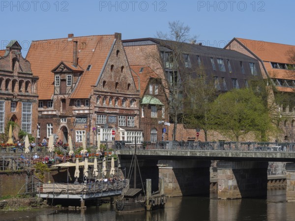 Charming half-timbered houses flank a river, while a bridge leads to a historic neighbourhood,
