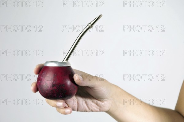 Hand and Yerba Mate drink on white background