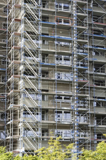 Scaffolded high-rise residential building with balconies and satellite dishes, Trabantenstadt
