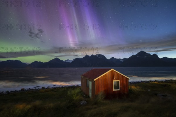 Northern Lights over a hut at the Lyngenfjord, Lyngen Alps, Lyngen, Troms og Finnmark, Norway,